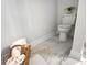 Bright bathroom featuring a white toilet, marble floors, and a stylish wicker basket holding soft white towels at 3292 N Highway 52, Saint Stephen, SC 29479