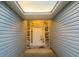 Covered entryway featuring a white front door with sidelights, a stone accent wall, and light blue siding at 3292 N Highway 52, Saint Stephen, SC 29479