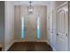 Foyer with hardwood floors, three-paneled white front door with sidelights, and designer light fixture at 3292 N Highway 52, Saint Stephen, SC 29479