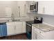 Bright kitchen with white cabinets, stainless steel appliances, hardwood floors, and gray marble countertops at 3292 N Highway 52, Saint Stephen, SC 29479