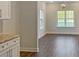 Living room with hardwood floors and bright windows near the kitchen with marble countertops and white cabinets at 3292 N Highway 52, Saint Stephen, SC 29479