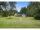Spacious, grassy backyard with mature trees, a shed, and a small bridge feature at 3378 Von Ohsen Rd, Ladson, SC 29485