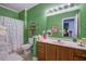 Green-themed bathroom featuring vanity with marble countertop and decorative floral shower curtain at 3378 Von Ohsen Rd, Ladson, SC 29485