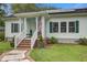 Inviting front porch with brick steps, white railings, and planters with colorful flowers at 3378 Von Ohsen Rd, Ladson, SC 29485
