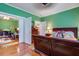 Primary bedroom featuring warm green walls, hardwood floors, and comfortable furniture at 3378 Von Ohsen Rd, Ladson, SC 29485