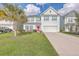 Charming two-story home featuring a well-manicured lawn, a palm tree, and a striking pink front door at 353 Dunlin Dr, Summerville, SC 29486