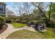 Inviting backyard features a stone patio with a fire pit, landscaping, and mature trees at 3558 Stockton Dr, Mount Pleasant, SC 29466