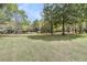 Expansive green backyard with mature trees overlooking a tranquil pond at 3734 St Ellens Dr, Mount Pleasant, SC 29466