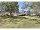 Backyard view of home with expansive lawn and mature trees, partially obscuring house at 3734 St Ellens Dr, Mount Pleasant, SC 29466