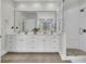 Bright bathroom featuring double sinks, white cabinets, a large mirror, and a glass-enclosed shower at 3734 St Ellens Dr, Mount Pleasant, SC 29466
