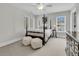 Bright bedroom with a four poster bed, plush white ottomans, and ample natural light from large windows at 3734 St Ellens Dr, Mount Pleasant, SC 29466