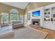 Inviting living room featuring a stone fireplace, built-in shelving, and large windows overlooking lush landscaping at 3734 St Ellens Dr, Mount Pleasant, SC 29466