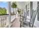 Inviting porch with rocking chairs, white pillars, and hanging plants, perfect for relaxing outdoors at 3734 St Ellens Dr, Mount Pleasant, SC 29466