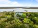 Stunning aerial view of coastal home surrounded by lush trees and waterfront with private docks on a sunny day at 377 Lofton Ct, McClellanville, SC 29458