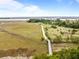 An aerial view of a home along a wooden foot bridge among marshes and waterways at 377 Lofton Ct, McClellanville, SC 29458