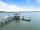 Dock on water with gazebo and a boat parked at the dock with seating for water views at 377 Lofton Ct, McClellanville, SC 29458