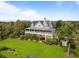 Beautiful exterior view of home with a metal roof, spacious porch, lush landscaping and mature trees at 377 Lofton Ct, McClellanville, SC 29458