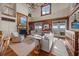 Elegant living room with a fireplace, wood paneling, large windows, and comfortable seating for relaxation at 377 Lofton Ct, McClellanville, SC 29458