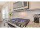 Close-up shot of a gas range with stainless steel hood and white subway tile backsplash at 400 Dunlin Dr, Summerville, SC 29486