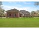 Expansive backyard with lush green lawn and brick home with a wooden deck at 4204 Magnolia Ct, North Charleston, SC 29420