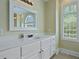 Bright primary bathroom features white cabinets, a large window, and an arched mirror at 4204 Magnolia Ct, North Charleston, SC 29420