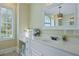 Bright primary bathroom features white cabinets, makeup mirror, and arched mirror at 4204 Magnolia Ct, North Charleston, SC 29420