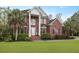 Stately brick home with prominent columns, lush landscaping, and a manicured lawn at 4204 Magnolia Ct, North Charleston, SC 29420