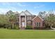 Stately brick home with white columns, manicured landscaping, and an American flag at 4204 Magnolia Ct, North Charleston, SC 29420