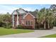 Beautiful brick home with columns, lush landscaping, and a well-maintained lawn at 4204 Magnolia Ct, North Charleston, SC 29420