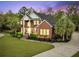 Elegant brick home at dusk featuring a grand facade and manicured lawn at 4204 Magnolia Ct, North Charleston, SC 29420