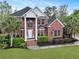 Impressive brick home with stately columns, a well-maintained lawn, and mature palm trees at 4204 Magnolia Ct, North Charleston, SC 29420