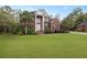Charming brick home with a large front lawn, stately columns, and mature palm trees at 4204 Magnolia Ct, North Charleston, SC 29420
