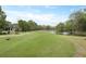 Scenic view of a meticulously maintained golf course with a pond and lush greenery, creating a tranquil setting at 4204 Magnolia Ct, North Charleston, SC 29420