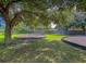 Community playground featuring swings, climbing structures, and mature trees for shade on a green lawn at 4701 Apple St, North Charleston, SC 29405
