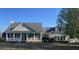 Charming home featuring a welcoming front porch, well-maintained lawn and mature landscaping at 527 W Butternut Rd, Summerville, SC 29483