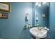 Charming half bath with a pedestal sink, unique decor, and a blue painted wall at 5276 7Th Green Dr, Hollywood, SC 29449