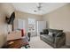 Bedroom with a ceiling fan, small couch, and window bringing in natural light at 5276 7Th Green Dr, Hollywood, SC 29449