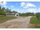 Picturesque horse barn with black accents and a dirt driveway under a blue sky with clouds at 5276 7Th Green Dr, Hollywood, SC 29449
