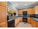 Functional kitchen with wood cabinetry, dark countertops, and a breakfast bar pass-through at 5276 7Th Green Dr, Hollywood, SC 29449