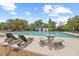 Resort-style community pool with ample seating, umbrellas, and a view of lush landscaping at 5276 7Th Green Dr, Hollywood, SC 29449