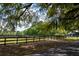 Long driveway to a country home surrounded by moss-draped trees and a fenced pasture at 5276 7Th Green Dr, Hollywood, SC 29449
