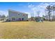 Large, blue two-story home with a spacious backyard, patio, and playset, perfect for Gathering fun at 547 Pontoon Rd, Huger, SC 29450