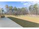 Spacious backyard features a playset, open lawn, and mature trees, perfect for outdoor activities at 547 Pontoon Rd, Huger, SC 29450
