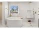 A bright and modern bathroom featuring a soaking tub, a glass-enclosed shower, and gold fixtures at 547 Pontoon Rd, Huger, SC 29450