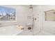 A bright and modern bathroom featuring a soaking tub, a glass-enclosed shower, and gold fixtures at 547 Pontoon Rd, Huger, SC 29450