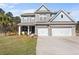 Charming two-story home with a brick facade, a welcoming front porch, and a two-car garage at 547 Pontoon Rd, Huger, SC 29450