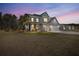 Two-story home featuring a manicured lawn, three-car garage and beautiful architectural details at 547 Pontoon Rd, Huger, SC 29450
