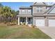 Inviting front entrance features a cozy porch, lovely landscaping, and a well-maintained lawn at 547 Pontoon Rd, Huger, SC 29450