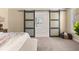A spacious main bedroom featuring sliding barn doors that lead to a luxurious ensuite bathroom with a soaking tub at 547 Pontoon Rd, Huger, SC 29450