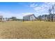 Expansive backyard features a two-story home, large open space, mature trees, and a playset at 547 Pontoon Rd, Huger, SC 29450